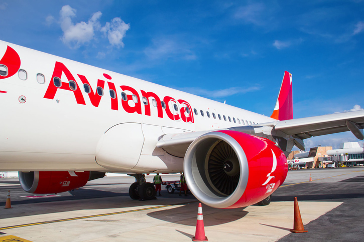 One of Avianca's distinctive red and white planes sits at an airport.