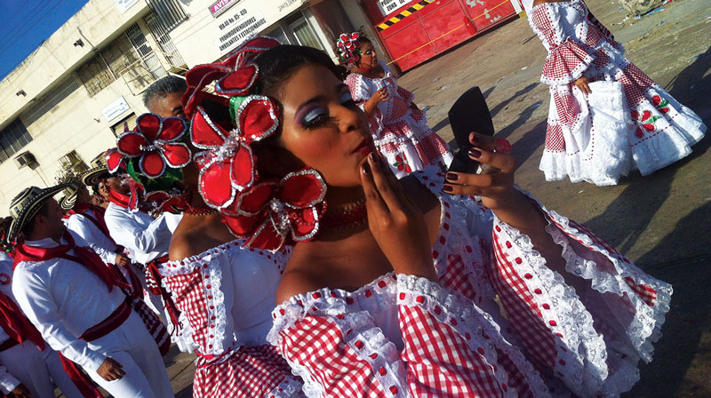 Dancers in red and white costumes getting ready for Carnaval in Barranquilla.