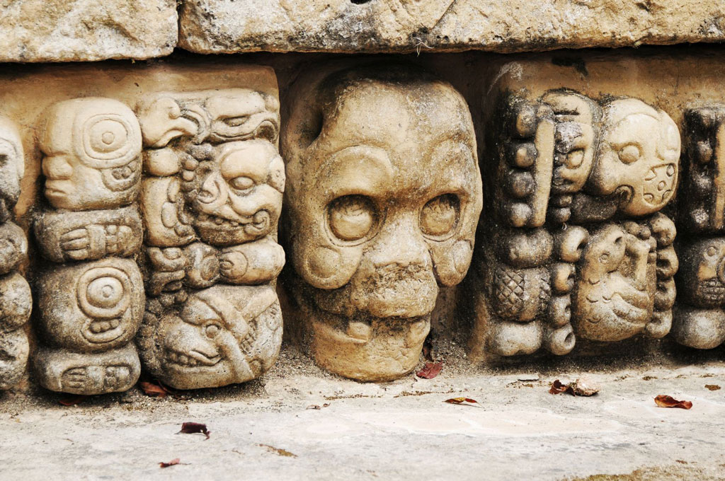 An inset carving of a skull alongside other carved figures.