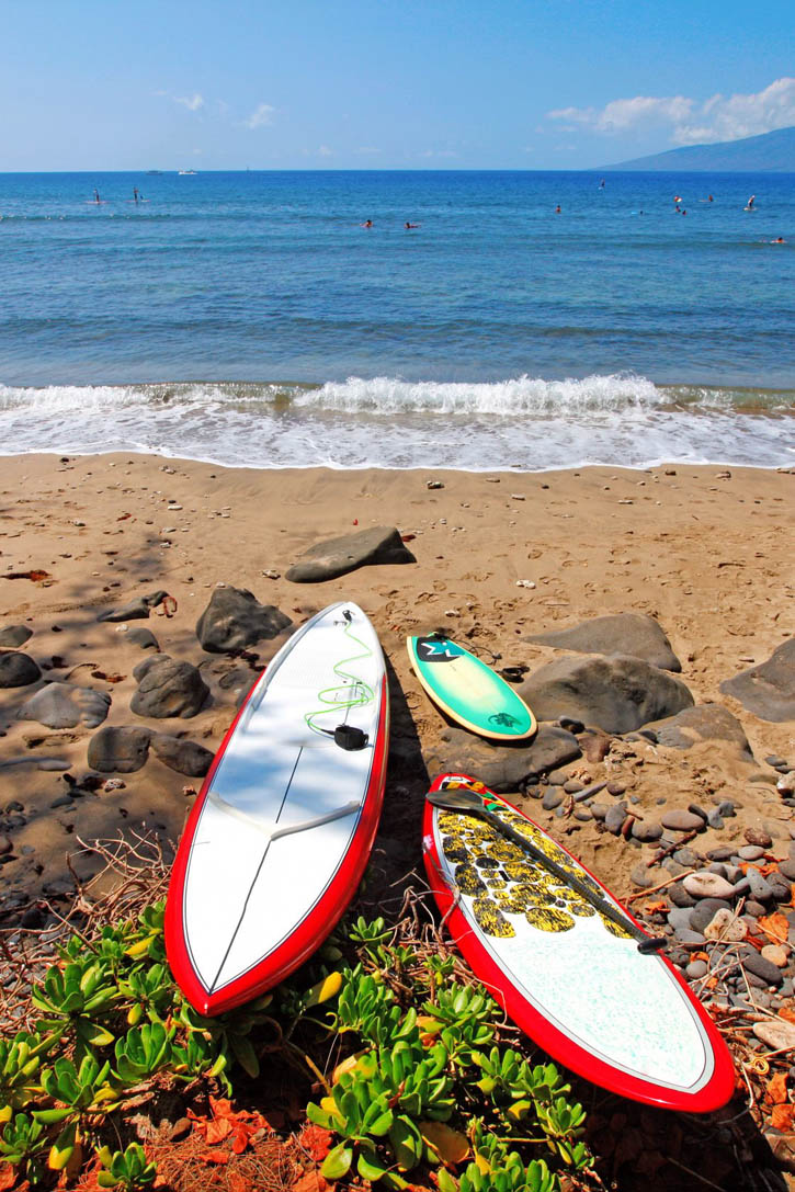 Surf boards in red and white on a Maui beach in Hawaii.