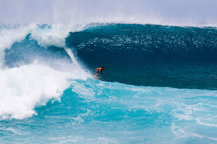 A surfer gets out in front of an enormous wave on the north shore of Oahu, Hawaii.